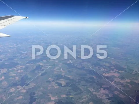 Sky up above the clouds viewed inflight on a passenger airplane. Stock Photos