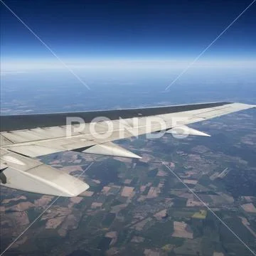 Sky up above the clouds viewed inflight on a passenger airplane. Stock Photos