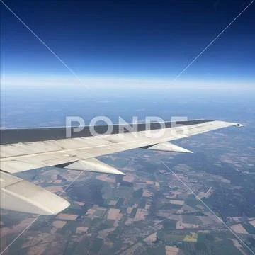 Sky up above the clouds viewed inflight on a passenger airplane. Stock Photos