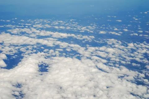The sky and clouds and the view seen in the window of the plane. Stock Photos