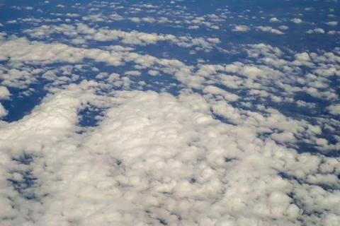 The sky and clouds and the view seen in the window of the plane. Stock Photos