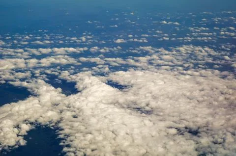 The sky and clouds and the view seen in the window of the plane. Stock Photos