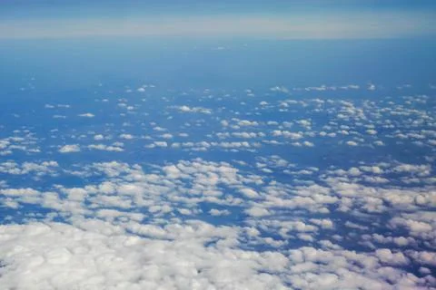 The sky and clouds and the view seen in the window of the plane. Stock Photos
