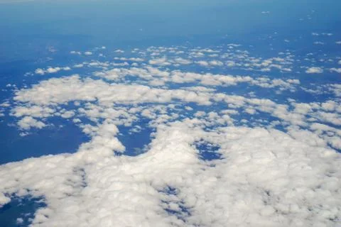 The sky and clouds and the view seen in the window of the plane. Stock Photos