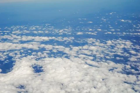 The sky and clouds and the view seen in the window of the plane. Stock Photos