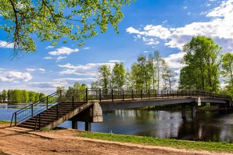 The sky and clouds are reflected in the water, the lake among the green trees Stock-Fotos