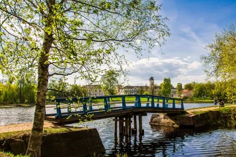 The sky and clouds are reflected in the water, the lake among the green trees Stock Photos