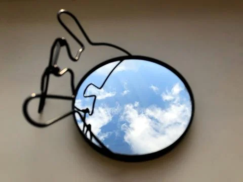 Sky and clouds reflected in a round mirror. Stock Photos