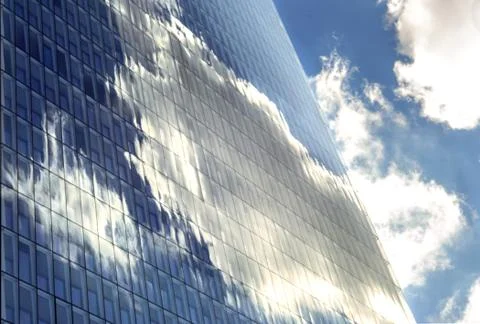 Sky and clouds reflected in windows of modern  tall office building. Stock Photos