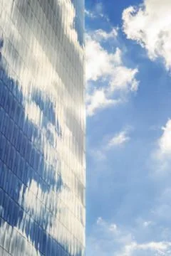 Sky and clouds reflected in windows of modern  tall office building. Stock Photos