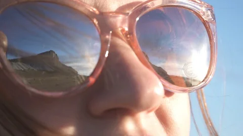 Sky and mountains are reflected in the glasses of a young girl Stock Footage 90954266