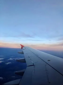 Sky and sunset from the plane window. Airplane wing. Open borders. Vertical Stock Photos