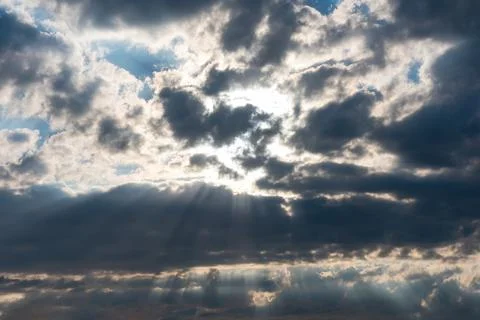 Sky background. Bright sunlight trough dark clouds. Copy space. Epic heaven 스톡 사진