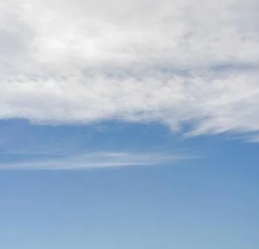 Sky background, lower part is clear blue, upper with cirrus clouds Stock Photos