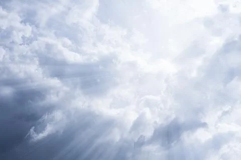 Sky background. The rays of the sun break through dense dramatic clouds Stock Photos