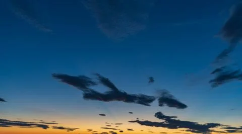 Sky background at sunset with blue clouds and orange skyline Stock Photos