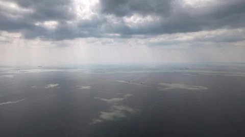 Sky beams pierce thick clouds above vast ocean Видео 332592420