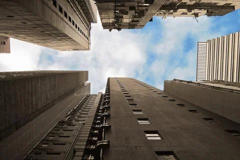 Sky between buildings. Low angle view from the ground on raising skyscrapers  스톡 사진