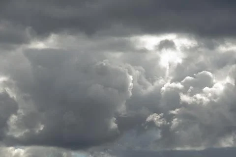 The sky is blanketed by massive, grey storm clouds. Stock Photos