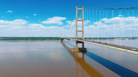 Sky brightens over sweeping river and massive suspension bridge Vidéo 343520014