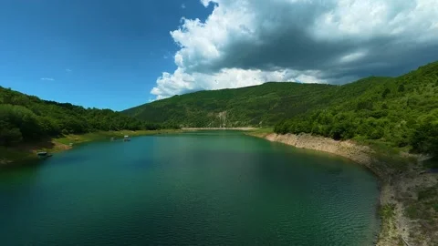 Sky casts shadows over calm, emerald waters. Zavoj Lake, Serbia Video stock 337489174