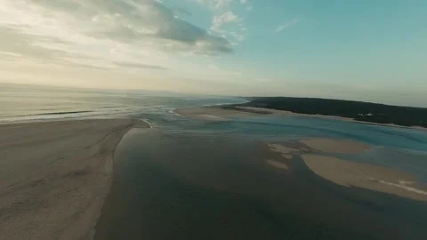 Sky casts warm glow over serene coastal bend Stock Footage 340227384