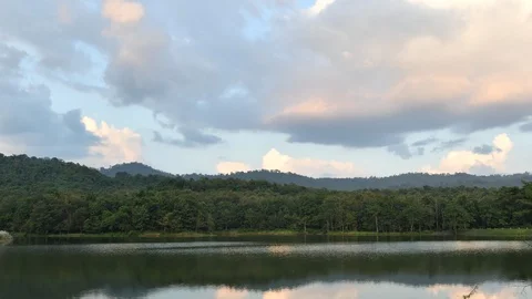 The sky is changing color in forests with mountains and rivers. Video stock 124675418
