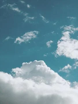 The sky is clear blue with fluffy white clouds Stock Photos