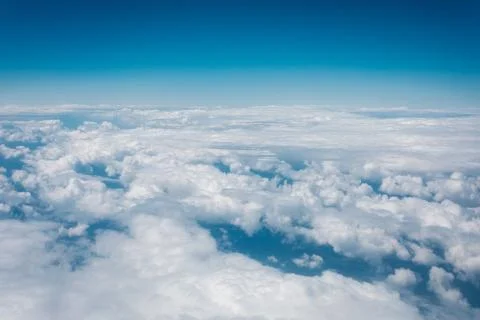 Sky with clouds from airplane window during flight. Stock Photos