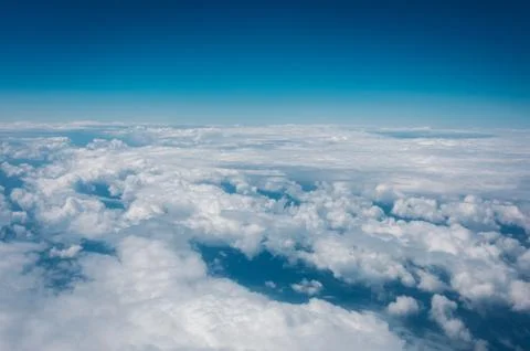 Sky with clouds from airplane window during flight. Stock Photos