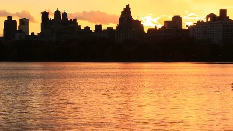 Sky, Clouds and Central Park Reservoir glow and illuminate by sunset Video stock 126558380
