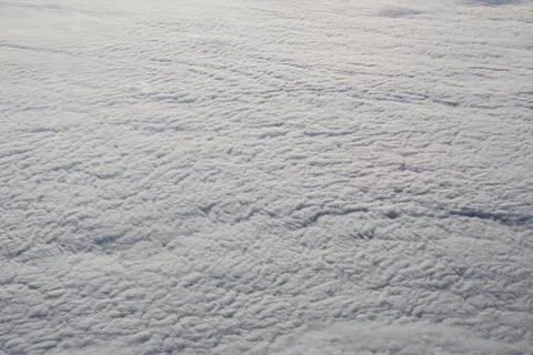 A sky with clouds and a plane flying above it Stock Photos