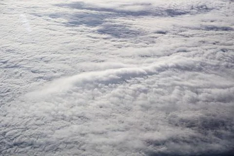 A sky with clouds and a plane flying above it Stock Photos