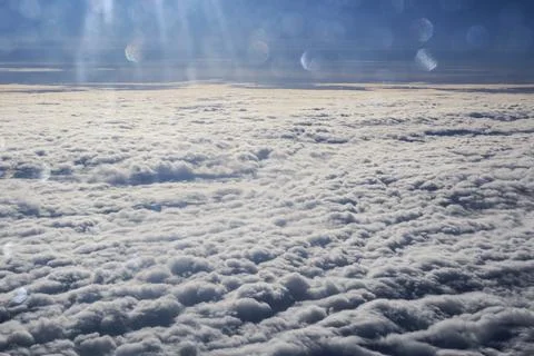 A sky with clouds and a plane flying above it Stock Photos