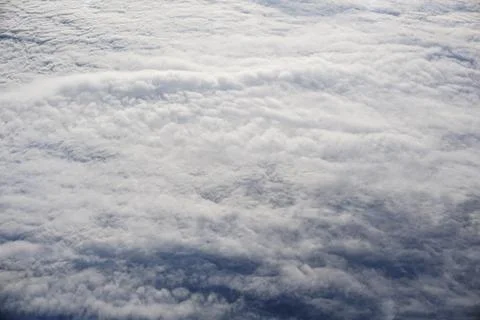 A sky with clouds and a plane flying above it Stock Photos