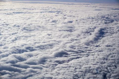 A sky with clouds and a plane flying above it Stock Photos