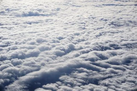 A sky with clouds and a plane flying above it Stock Photos