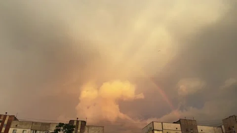Sky with clouds and rainbow above the buildings during sunset Stock Footage 339793421