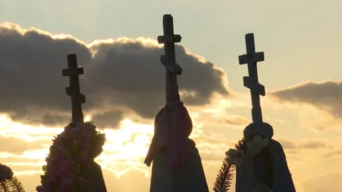 Sky with clouds and the setting sun, silhouettes of ancient stone crosses,  Stock Footage 150257003