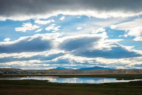Sky with clouds are displayed on the surface of the lake. Shevelev. Stock Photos