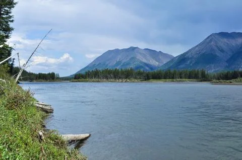 The sky in the clouds over the mountain river. Stock Photos