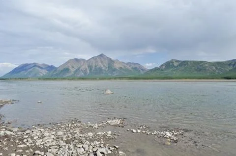 The sky in the clouds over the mountain river. Stock Photos