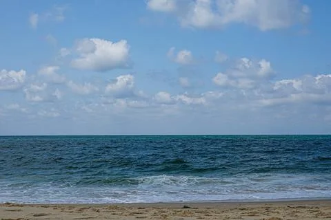 Sky with clouds over the ocean with sandy shore. Stock Photos