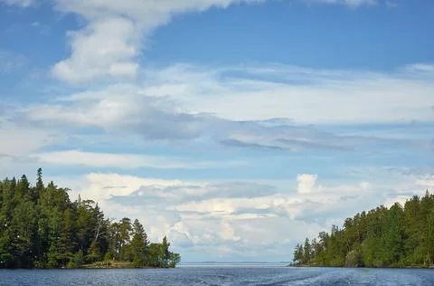 Sky with clouds over the water. a trace of a boat on the water surface, waves Stock Photos