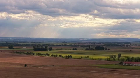 Sky with clouds with rays of sun shining through falling on the landscape of Stock Footage 316296429