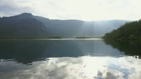 The sky with clouds reflecting in a calm mountain lake on a sunny day Stock Footage 164558429