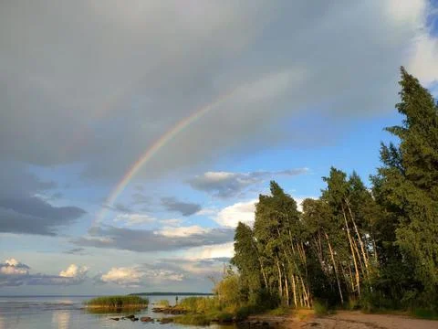 Sky, clouds, shore, rainbow Stock Photos