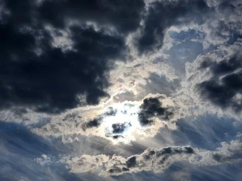 Sky with clouds. Sun behind dark clouds Stock Photos
