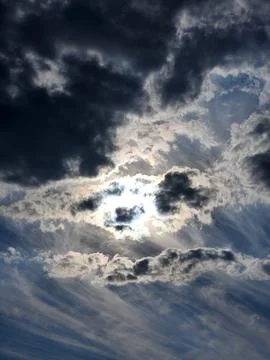 Sky with clouds. Sun behind dark clouds Stock Photos