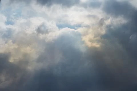 Sky with clouds through which heavenly light pours, sunlight passes through t Stock Photos